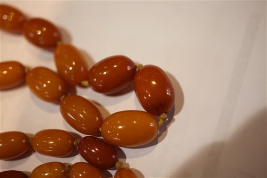 A single strand graduated oval amber bead necklace, 32in.
